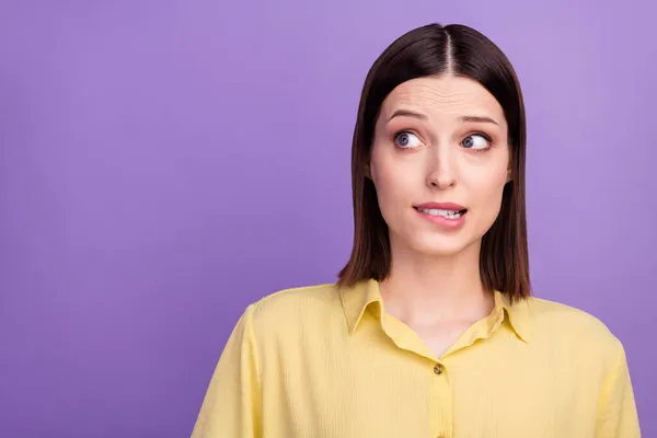 Foto van jonge mooie dame bijten lippen tanden bezorgd schuldig falen kijken lege ruimte geïsoleerd over violette kleur achtergrond — Stockfoto