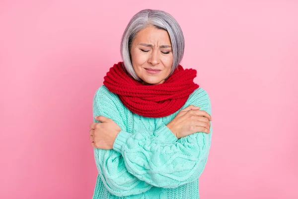 Фото седой причёски пожилой женщины, обнимающей себя, носит шарфовый свитер, изолированный на розовом фоне. — стоковое фото