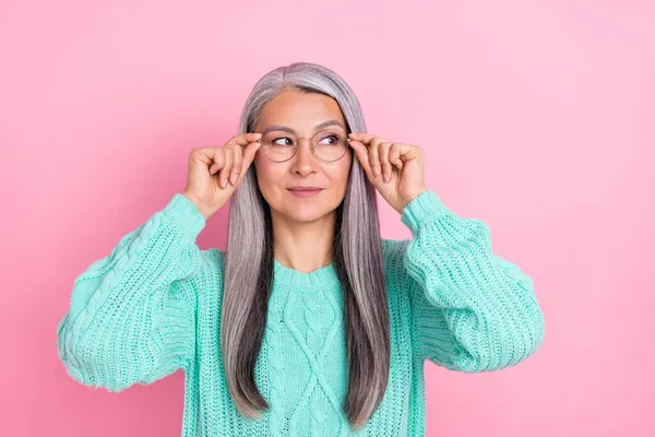 Foto de optimista gris peinado anciano señora mirada espacio vacío desgaste gafas verde jersey aislado sobre fondo de color rosa —  Fotos de Stock
