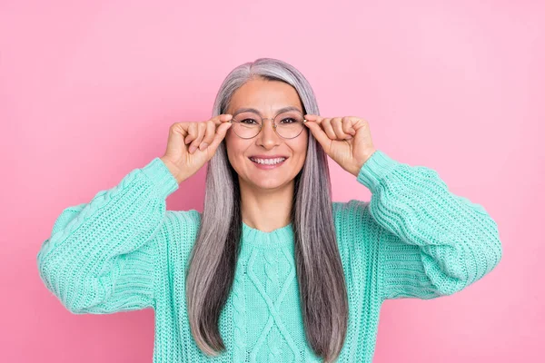 Foto de dulce gris peinado anciana manos gafas desgaste verde azulado jersey aislado sobre fondo de color rosa — Foto de Stock