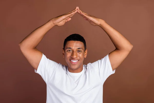 Afrikalı genç bir adamın el ele tutuşurken çekilmiş fotoğrafı. Kahverengi arka planda izole edilmiş yeni bir ev satın al. — Stok fotoğraf