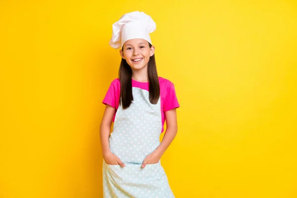 Foto di fiducioso bella ragazza tasche finitura cena indossare bianco grembiule cappello isolato colore giallo sfondo — Foto Stock