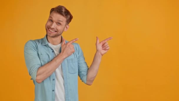 Чарісматичний промоутер блондин веселий хлопець вказує на порожній порожній простір банерів — стокове відео