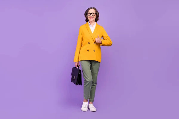 Full size foto van vrolijke positieve oude dame maken duim-up hold koffer bedrijf geïsoleerd op paarse kleur achtergrond — Stockfoto
