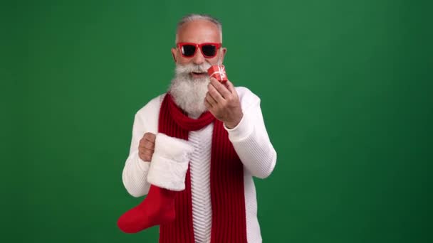 บ้าร่าเริงซานต้าถือถุงเท้าคริสต์มาสโยนของขวัญเล็ก ๆ — วีดีโอสต็อก