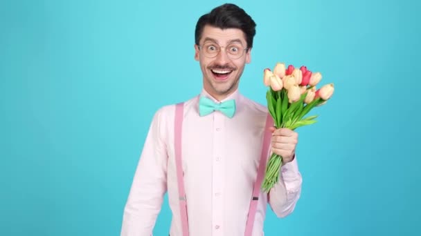 Pozitivní sebevědomí cool nerd přítel držet kytici tulipány upravit luk — Stock video