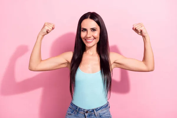 Foto retrato bastante morena en singlet azul mostrando fuertes músculos feminista aislado pastel rosa color fondo —  Fotos de Stock