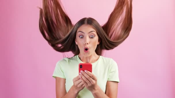 Возбужденный шокированный леди держать телефон читать сумасшедшие новости после прически замедленного падения — стоковое видео
