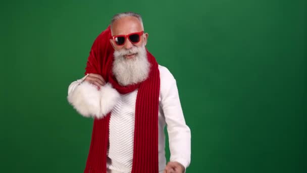 Fröhlicher Rocker-Opa Weihnachtsmann zeigt Hörner-Geste und überreicht Sackgeschenke — Stockvideo