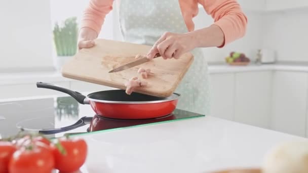 Vágott nézet hölgy karok tartsa vágódeszka kés dobja csirke filé serpenyő — Stock videók