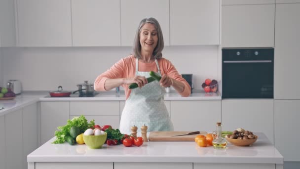 Сумасшедшая бабушка готовит салат держать огурец микрофон петь караоке песня кухня диско танец — стоковое видео
