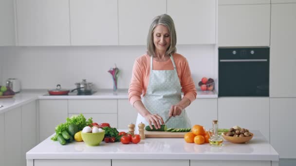 Positiv vorsichtig reif lady cut gurke studio blogger kochen lektion konzept — Stockvideo