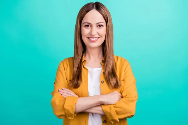 Foto de confiante muito jovem mulher vestida camisa amarela sorridente braços cruzados isolado teal cor fundo — Fotografia de Stock