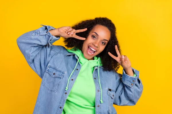 Foto de atraente mulher afro funky usar jaqueta de ganga mostrando dois v-sinais sorrindo isolado fundo cor amarela — Fotografia de Stock