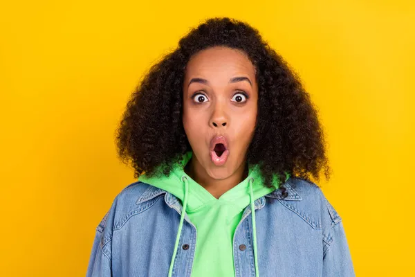 Foto de chocado bela senhora africana vestida jeans verde com capuz olhos grandes boca aberta isolado cor amarela fundo — Fotografia de Stock