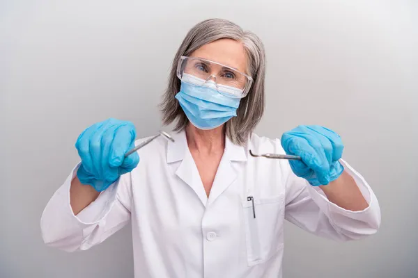 Φωτογραφία του χαρούμενου επαγγελματία ώριμη γιατρός φορούν γυαλιά λευκό παλτό έτοιμο διαγνώσει τα δόντια σας απομονωμένο γκρι χρώμα φόντο — Φωτογραφία Αρχείου
