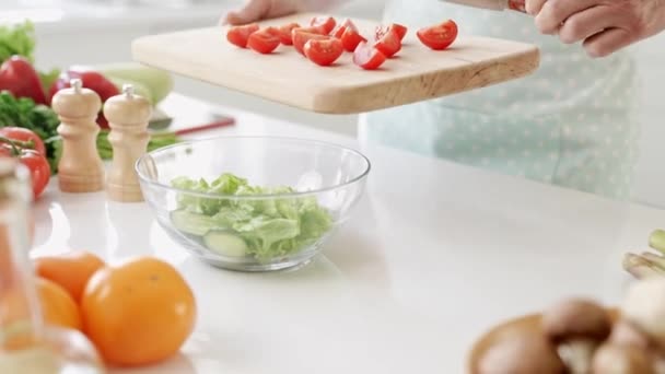 Gesneden uitzicht volwassen dame armen toevoegen gesneden tomaat voor te bereiden salade — Stockvideo