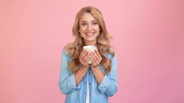 Señora rubia madura pacífica celebrar taza de té disfrutar de rico sabor — Vídeos de Stock