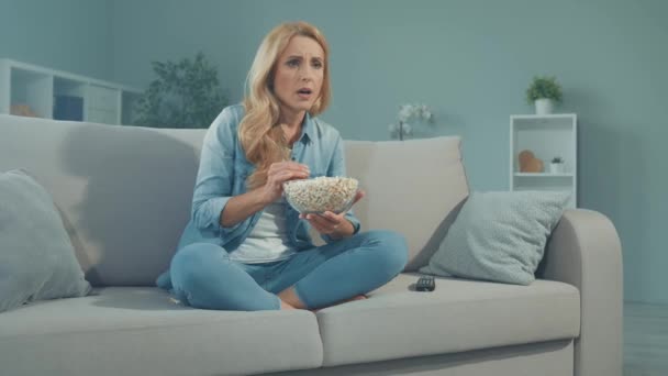 Stressed lady eat pop corn watch intense soap opera drama movie — Stock Video