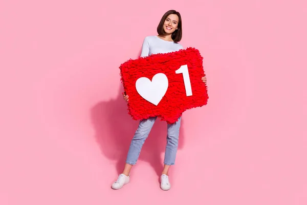 Foto de mulher jovem adorável brilhante usar camisola branca andando segurando grande como sinal de coração sorrindo isolado cor de fundo rosa — Fotografia de Stock