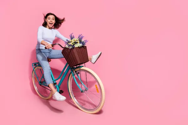 Foto de brilhante funky jovem senhora vestida jumper branco equitação bicicleta rápida espaço vazio isolado cor rosa fundo — Fotografia de Stock