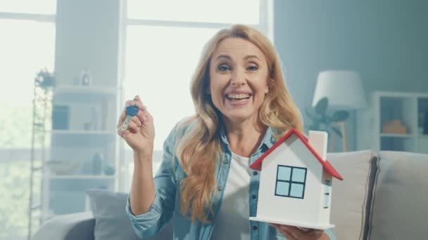 Agente inmobiliario confiable positivo mantenga llaves de la figura de la casa oferta especial apartamento — Vídeo de stock