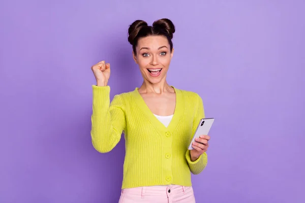 Foto de jovens felizes positivo animado louco menina levantar punho na vitória uso smartphone isolado no fundo cor violeta — Fotografia de Stock
