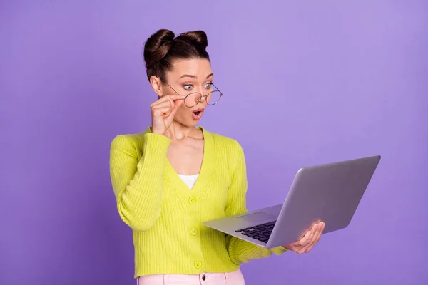 Foto di giovane bella scioccato stupito ragazza sorpresa in occhiali che lavorano in computer portatile isolato su sfondo di colore viola — Foto Stock