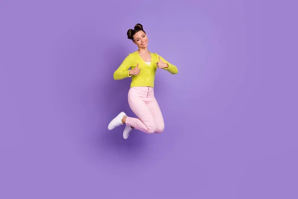 フルサイズ写真の若いです幸せな笑顔正の女の子ジャンプショー親指アップ絶縁上の紫色の背景 — ストック写真
