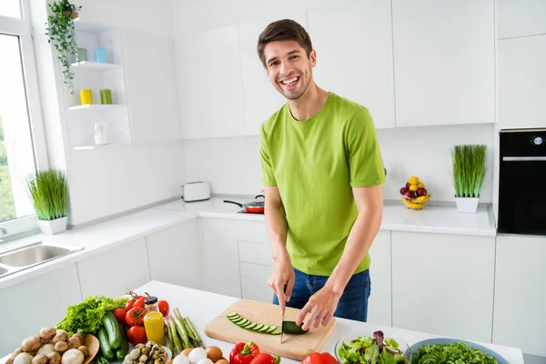 Çekici, neşeli adamın portresi açık beyaz mutfak evinde lezzetli ev yemekleri hazırlıyor. — Stok fotoğraf
