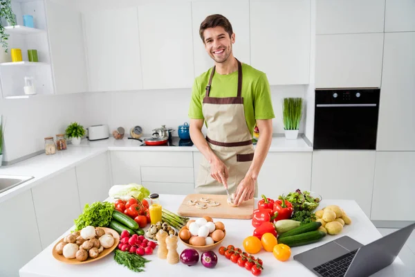 Çekici, neşeli adamın portresi ev yapımı taze ev yemeği hazırlıyor açık beyaz mutfak evinde sebze kesiyor. — Stok fotoğraf