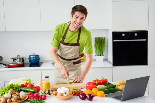 실내에 있는 밝은 흰색 부엌에서 유용 한 야채를 자르는 신선 한 자연 체중 감량 식사를 준비하고 있는 매력적 인 명랑 한 남자의 모습 — 스톡 사진