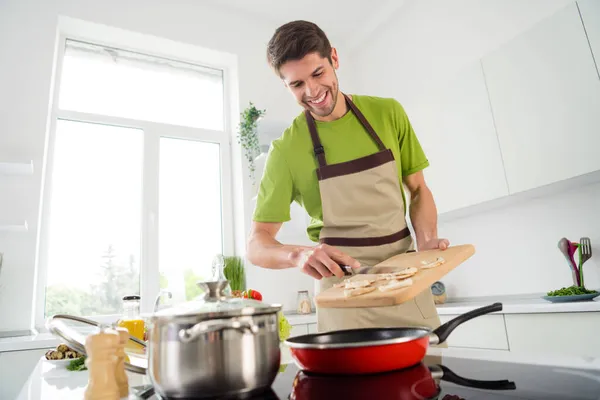 魅力的な陽気な男の肖像｜家庭用キッチンでおいしい食材をフライパン屋内で調理 — ストック写真