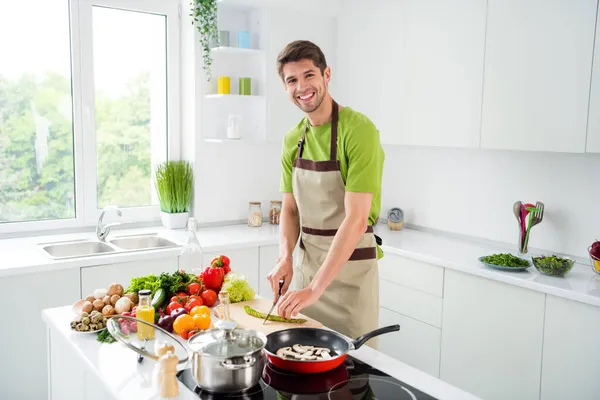 Çekici, neşeli bir adamın portresi ev mutfağında leziz bir gurme restoranı hazırlıyor. — Stok fotoğraf