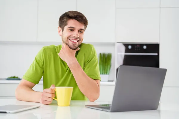 Retrato foto homem usando laptop sentado na cozinha beber café trabalhando remotamente tenho ideia — Fotografia de Stock