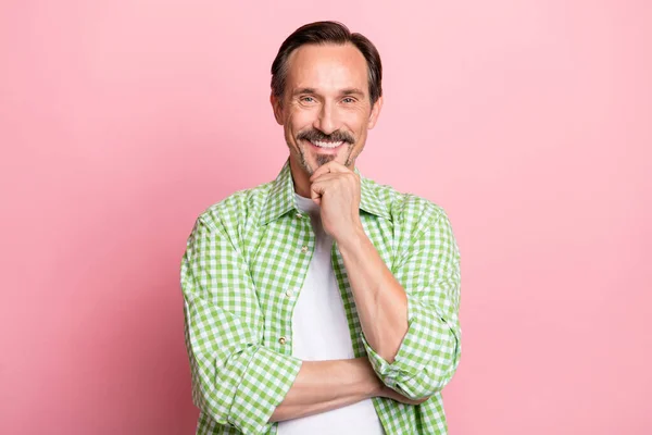 Photo of thoughtful confident age man wear green checkered shirt arm chin smiling isolated light pastel pink color background — Stock Photo, Image