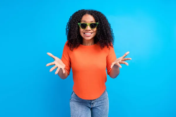 Foto van verbaasd gelukkig positief afro-Amerikaanse jonge vrouw hand dragen zonneglas geïsoleerd op blauwe kleur achtergrond — Stockfoto