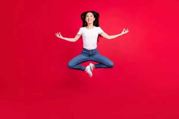 Foto ukuran penuh gadis muda Asia yang menarik bahagia lompatan senyum positif meditasi yoga asana tenang terisolasi dari latar belakang warna merah — Stok Foto