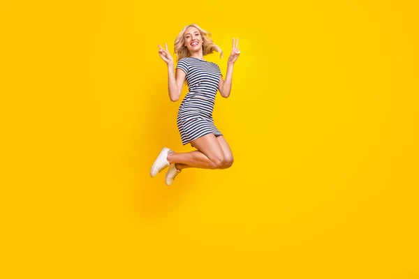 フルレングスボディサイズ写真女性ジャンプアップ表示v-signジェスチャー絶縁鮮やかな黄色の背景色 — ストック写真