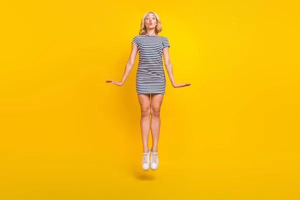 Comprimento total tamanho do corpo foto mulher pulando com lábios despojados isolado vibrante cor amarela fundo — Fotografia de Stock
