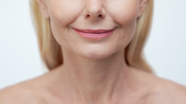 Обрезанный вид улыбки пенсионерки, сияющей блестящими зубными имплантатами — стоковое видео