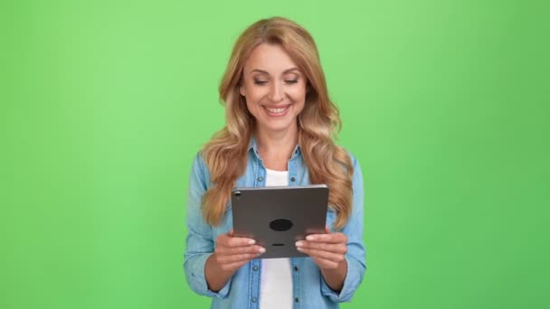 Krásná zralá dáma držet tablet číst sociální média krmit lesklý úsměv — Stock video