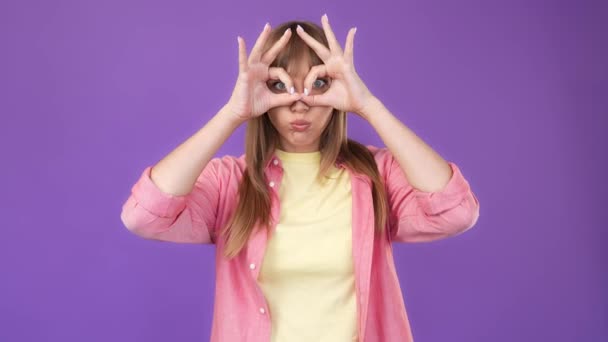 Lucu bodoh wanita positif menunjukkan teropong jari menutupi mata bersenang-senang — Stok Video