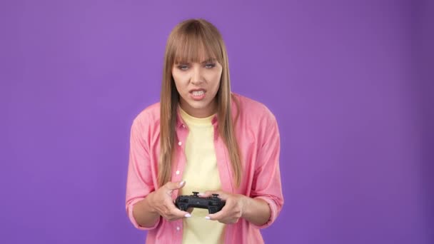 Сумасшедшая зависимая геймерша удерживает контроллер проигрывает матч по видеоиграм — стоковое видео