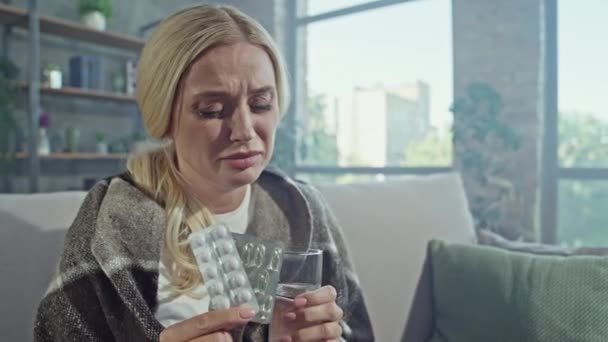 Vyčerpaná ustaraná dáma držet léky skleněná voda cítit špatně — Stock video