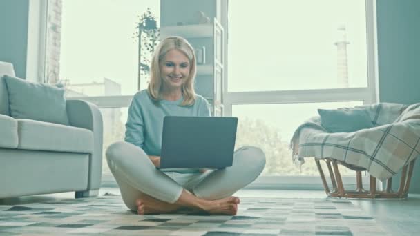Σίγουρη θετική κυρία κάθονται πάτωμα κρατήσει netbook κάνει απομακρυσμένη δουλειά — Αρχείο Βίντεο