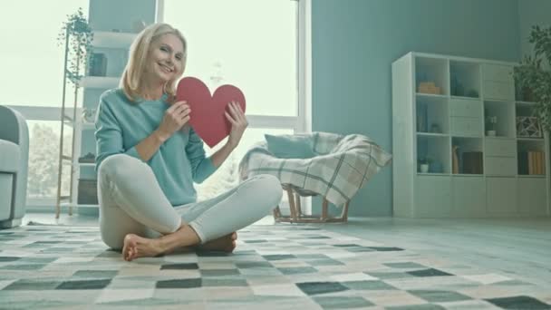 Señora cariñosa romántica sostiene símbolo de papel rojo corazón — Vídeos de Stock