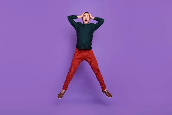 写真の興奮ショックを受けた若い男服を着てスマートカジュアル服ジャンプ高腕頭隔離された紫色の背景 — ストック写真