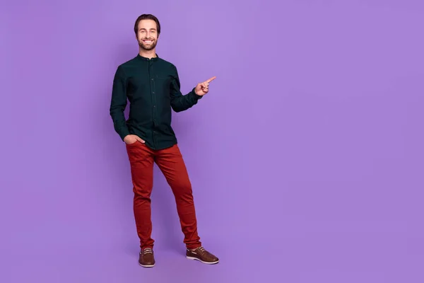 Bild av charmig rolig ung kille klädd smart casual kläder pekar finger tomt utrymme isolerad violett färg bakgrund — Stockfoto