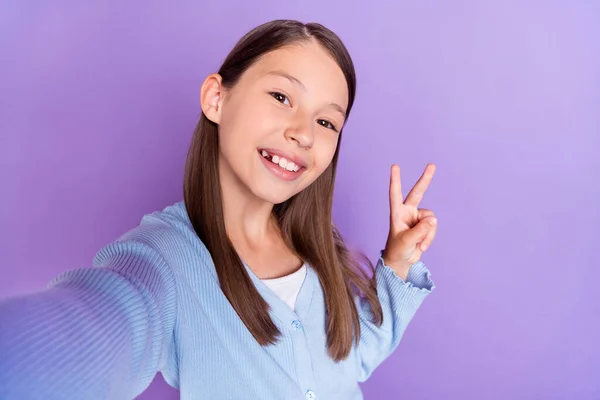 Foto da menina morena otimista fazer selfie mostrar v-sign desgaste camisa azul isolado no fundo cor violeta — Fotografia de Stock